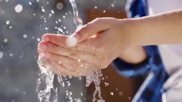 A stream of wet transparent clean water is poured onto the hands, observe the hygiene of clean human skin, moisturize and wash fingers, clean and wash after work, wash off the dirt, close-up — Stock Video
