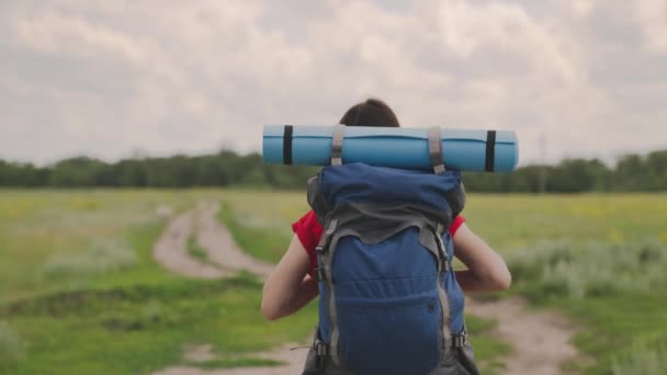 Aktív lány hátizsák pihen egy kemping utazás, egy millenniumi utazó, túrázás a természetben, életmód egy modern férfi, séta a földúton, lassított felvétel — Stock videók
