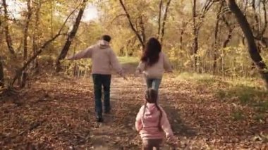 Küçük çocuk anne ve babasına yetişiyor, mutlu aile, aktif çocuklar, sonbaharda açık hava oyunları, neşeli çocuk anne ve babasıyla gülüyor, birlikte tatile çıkıyor, çocuklar eğlenceli rüyalar görüyor.