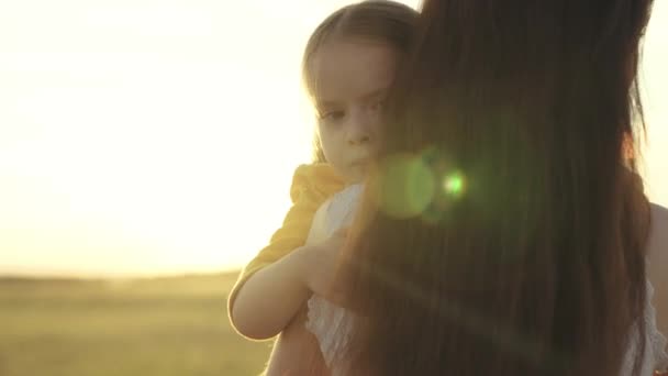 Küçük çocuk güneşin altında annesine sarılıyor, gün batımında mutlu bir aile, kadın çocuğu seviyor, anneliği güzel bir duygu, annesiyle birlikte gökyüzüne doğru bir yolculuğa çıkıyor, bebeğin velayeti... — Stok video