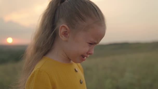 Een klein overstuur kind huilt bij zonsondergang, tranen stromen naar beneden de kinderen gezicht, een uitdrukking van ontevredenheid emotie, schreeuw van stress van de ziel, meisje wil niet gehoorzamen, kind probleem nat gezicht — Stockvideo