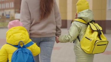 Anne, sırt çantalı çocukları okula götürüyor, mutlu aile, okul çantalı çocuk hemen derse koşuyor, okul zili çalıyor, bebekler ilkokula gidiyor, çocuklar eğitim görüyor.