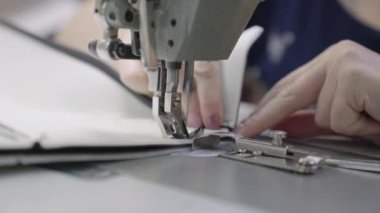 Bir fabrikanın dikiş makinesine ceket dikmek, dikiş dikmek, bir iş tasarımcısı, bir terzi desenlerin detaylarını diker, bir kadın el sanatları, modaya uygun şeylerin üretimi.
