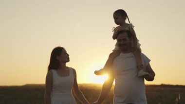 baba ve çocuk gün batımında gökyüzünde koşuyorlar, mutlu aile silueti, küçük çocuk babasının omuzlarında oturuyor, aile gezisi, eğlenceli anne-baba ve kız, açık hava süper kahramanı, birlikte haftasonu