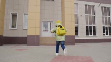 Sırt çantalı küçük çocuk ders için okula koşuyor, okul çantalı çocuk sınıfa koşuyor, ilkokul öncesi eğitim, mutlu aile, ek öğrenci aktiviteleri.