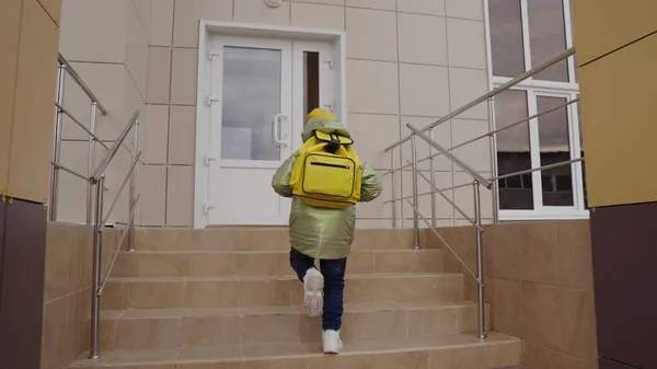 Bambino piccolo con zaino si precipita a scuola per la lezione, bambino con borsa scolastica sulle spalle corre in classe, istruzione prescolare primaria per bambini, famiglia felice, ulteriori attività studentesche — Foto Stock