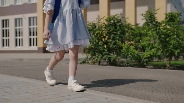 Bonne petite fille jouant dans la cour d'école, un petit enfant avec un sac à dos, un sac d'école pour enfants sur les épaules des bébés, une éducation primaire amusante pour les enfants, un rêve d'enfance, une vie scolaire amusante — Photo