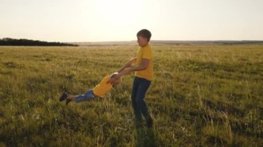 Çocuklar yeşil bir alanda dönüyorlar, mutlu çocuklar doğada oynuyorlar, çocukluk arkadaşları, komik çocuklar baş döndürücü bir oyun oynuyorlar, mutlu aile dışarıda, hayatla eğleniyorlar.