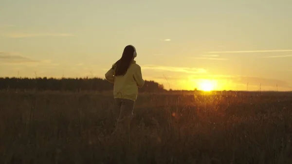 Girl runs at sunset in a tracksuit, jogging actifa cardio workouts, fitness jogging in the sun, athletic young woman preparing for a competition, healthy lifestyle and a good figure of a mans dream — Stock Photo, Image