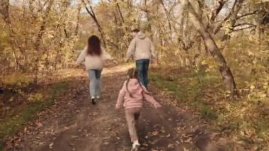 Küçük çocuk anne ve babasına yetişiyor, mutlu aile, aktif çocuklar, sonbaharda açık hava oyunları, neşeli çocuk anne ve babasıyla gülüyor, birlikte tatile çıkıyor, çocuklar eğlenceli rüyalar görüyor.