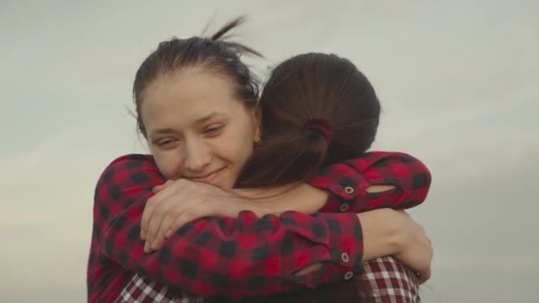 Mädchen umarmt ihre Freundin in der Natur, glückliche Familie, Tochter lächelt auf Mamas Schulter, Vertrauen in die Beziehungen der Menschen, Freundlichkeit und Unterstützung mit gutem Lächeln Emotionen, aufrichtige Zärtlichkeit Tag Dankbarkeit — Stockvideo