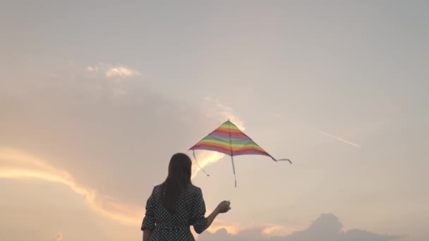無料の女の子は日没の空に凧を起動し、旅の楽しみを持っている、自然の楽しさの屋外で遊ぶ、飛ぶ夢、自然の中で虹色の遊びと女性の週末、上記の風をキャッチ — ストック動画