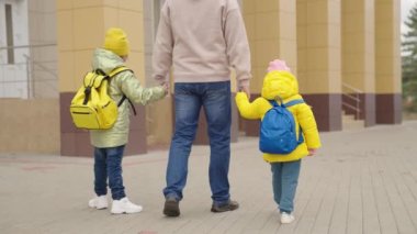 Okul sınıfları, babalar sırt çantalı çocukları, mutlu aileyi, çocuklarla okul bahçesinde yürür, okul öncesi eğitim, okul öncesi eğitim, okul çantası omuzları...