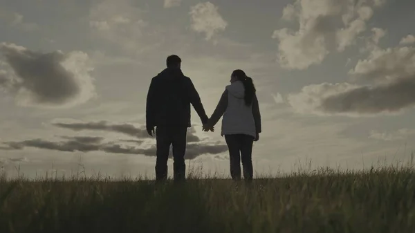 Silhouet van een man en een vrouw bij zonsondergang, hand in hand een partner in de zon, teamwork, corporate happy farming groep, succesvol business team, vertrouwen van succesvolle mensen, vreugde van de vereniging — Stockfoto