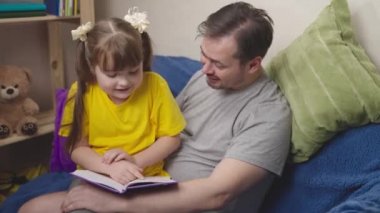 Babasıyla birlikte çocuk ilginç bir kitap okudu. Kahkaha attı, okul ödevlerini babasıyla uzaktan okudu. Küçük kız babasıyla peri masalı, dünya bilgisi ve mucizeler üzerine güldü.