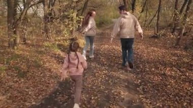 Çocuk, anne babasıyla sonbahar ormanlarına yetişmek için koşuyor, küçük kız, ebeveynleriyle oyun oynuyor, neşeli çocukluk doğası, mutlu aile hayatı, birlikte eğleniyor, aktif eğlence grubu insanları.