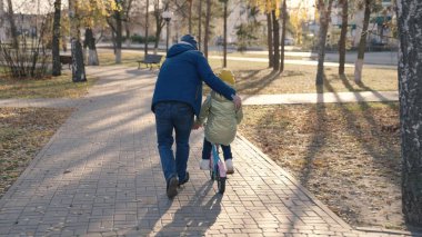 Neşeli baba iki tekerlekli bisiklete binmeyi öğretir mutlu aile, çocukluk hayali bisikletli çocuk baba neşeyle şehir parkı oynar bebek pedalları çevirir, kızıyla nişanlı ata biner
