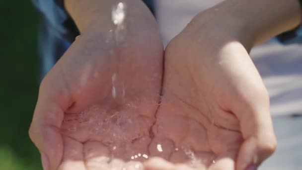 Wasserblasen in der menschlichen Hand tropfen und spritzen in verschiedene Richtungen, Öko, halten sauberes Wasser für Menschen, Umweltschutz, achten Sie auf saubere Hände, Hauthygiene, Planschen in klarem Wasser — Stockvideo
