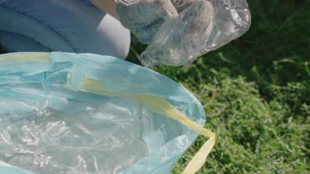 手拿着塑料瓶装袋，垃圾处理，生态，保持环境清洁，绿色星球安全，自然森林生态系统，环境保护问题，慈善活动 — 图库视频影像
