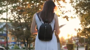 Şehrin güneş ışınlarında bir tablette okuyan, çevrimiçi bir mağazada gün batımında online alışveriş yapan, sosyal ağlarda e-postaları kontrol eden, sohbet eden, bilgi kaynaklarında kitap okuyan ve haberler okuyan bir kız.