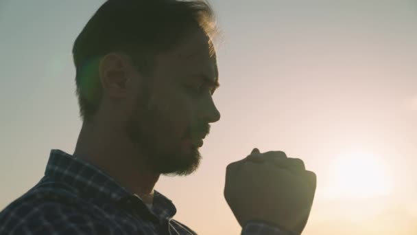 Hombre orando al atardecer, pidiendo ayuda y apoyo al cielo, hombre espiritual contemplando, el concepto de fe y esperanza, reflexiones en los rayos del sol, religión confiable — Vídeos de Stock