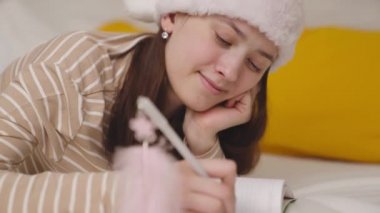 Noel Baba şapkalı bir kız Noel dileği yazar, yeni yıl tatili, çocukluk hayalleri, mutlu bir ergenden tebrik mektubu, bir şenlik mucizesi bekler, yılın sürprizini bekler.