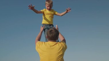 Baba, neşeli küçük çocuğu gökyüzüne fırlatır, çocukça hayaller kurar, çocuk pilot olmak ister, mutlu aile hayatı, açık havada bebek oyunu oynamak ister, gülen oğul ayağa fırlar, baba günü, birlikte zaman geçirmek ister.