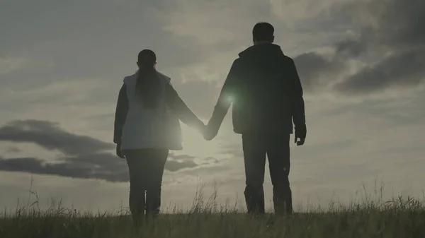 Silhouette of a man and a woman at sunset, hold a partners hand in the sun, teamwork, corporate happy farming group, successful business team, trust of successful people, joy of joining unity — Stock Photo, Image