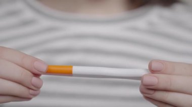 Bir kadının elinde gebelik testi, iki şeritten kaynaklanan endişe verici bir sonuç, kız çocukları gecikti, sağlıklı anne küçük bir bebek bekliyor, kadın eğlencesi ve ciddi rahatsızlıklar, evde sağlık kontrolü