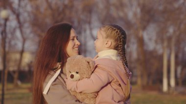 çocuk oyuncak ayı, çocuk anne, küçük kız, kucaklayan çocuk, kollarında mutlu aile, mumya parkı olan çocuk, favori oyuncak bebek, annelik ve bakıcılık, anne gülüyor ve gülümsüyor.