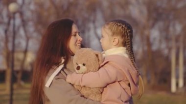 çocuk oyuncak ayı, çocuk anne, küçük kız, kucaklayan çocuk, kollarında mutlu aile, mumya parkı olan çocuk, favori oyuncak bebek, annelik ve bakıcılık, anne gülüyor ve gülümsüyor.