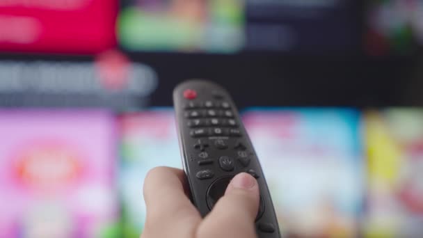 TV-fjärrkontroll, smarta hushållsapparater, knapptryckning program, välj filmer på displayen, titta på TV-nyheter på kvällen, bläddra igenom suddig händelse bandet ändras på skärmen, Internet-TV — Stockvideo