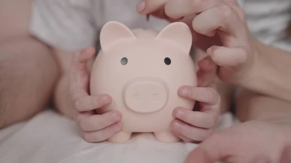 Budget of a happy family, a hold on the future of life, a family security pillow, a pig piggy bank collects money, father and mother give cash a child, the concept of a childs dream of saving coins — Stockfoto
