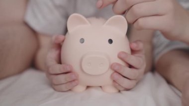 Mutlu bir ailenin bütçesi, hayatın geleceği, aile güvenlik yastığı, domuz kumbarası para toplar, anne ve baba çocuğa para verir, madeni para biriktirme hayali.
