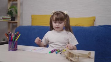 Küçük kız bir albümde renkli kalemlerle resim çiziyor, okul masasındaki çocuk güzel sanatlar dersi alıyor, çocuğun en sevdiği çizim hobisi, evde tek başına yaşayan aktif bir liseli kız.