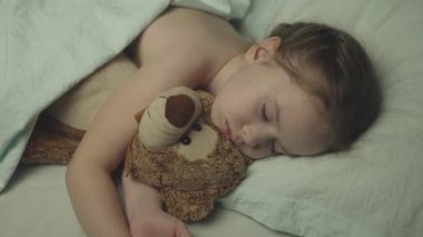 Küçük bebek geceleri beşiğinde uyur. Oyuncak ayıyla kucaklaşır. Kız çocuğu gözleri kapalı yatarken rüya görür.