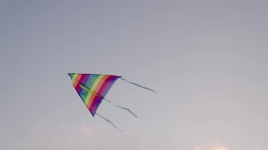 Gökyüzü arka planında uçurtma, uçarak uçan çocuklar, rüzgarda uçurtma uçuran gökkuşağı oyunu, mutlu tatiller, doğanın tadını çıkarın.