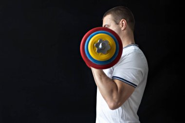 Güçlü, kaslı, halterle antrenman yapan sağlıklı bir adam. Evde fitness