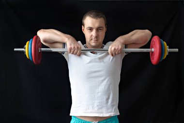 Güçlü, kaslı, halterle antrenman yapan sağlıklı bir adam. Evde fitness