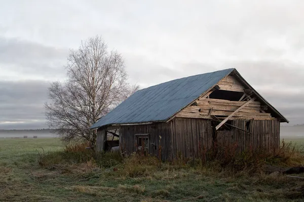 放棄された納屋の家は秋の畑の上に立っている 霧が立ち上がり 畑と納屋の両方をゆっくりと覆っています — ストック写真