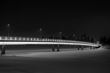 Kış gecesinde körfezin üzerinde bir köprü. Köprünün korkulukları çok güzel aydınlatılmış..
