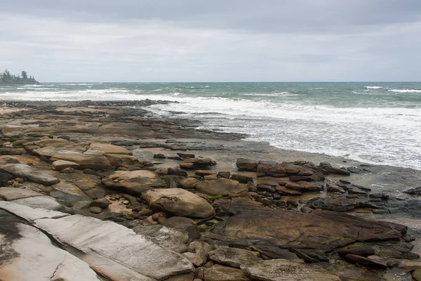 Rüzgar şiddetleniyor ve dalgalar kayalık sahilde kıyıya vuruyor..