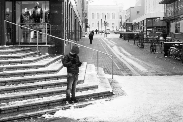 Rapaz Está Olhar Para Telemóvel Meio Queda Neve Parece Estar — Fotografia de Stock
