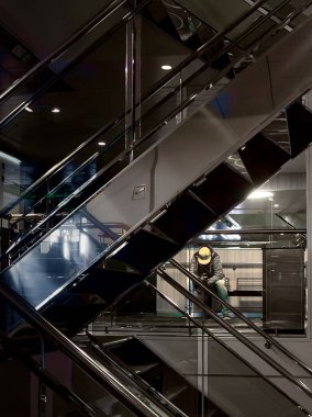 Genç bir adam merdivenlerde oturuyor ve feribotta telefonuna bakıyor..