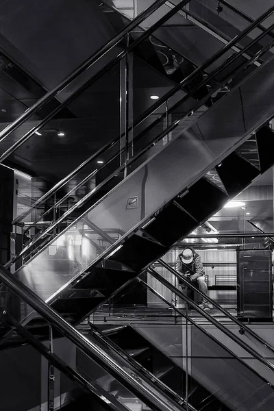 Genç bir adam merdivenlerde oturuyor ve feribotta telefonuna bakıyor..