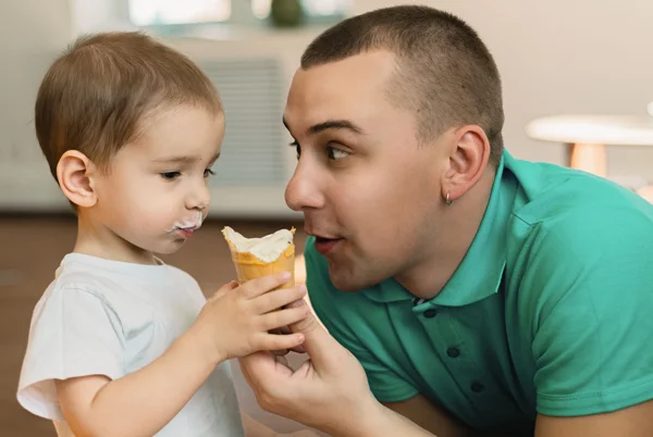 Niño comiendo helado en compañía de su padre —  Fotos de Stock