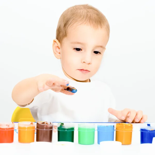 Malý chlapec kreslí prsty barvou — Stock fotografie