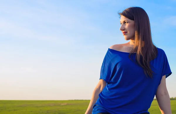 Bella giovane donna sullo sfondo del cielo e del campo — Foto Stock