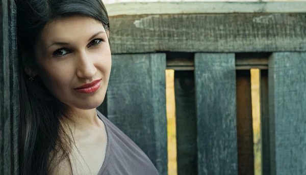 Portrait of a beautiful young woman on a wooden background — Stock Photo, Image