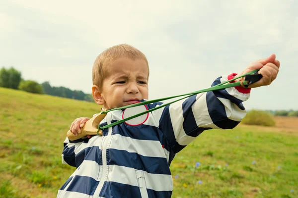 Un garçon apprend à tirer une fronde — Photo